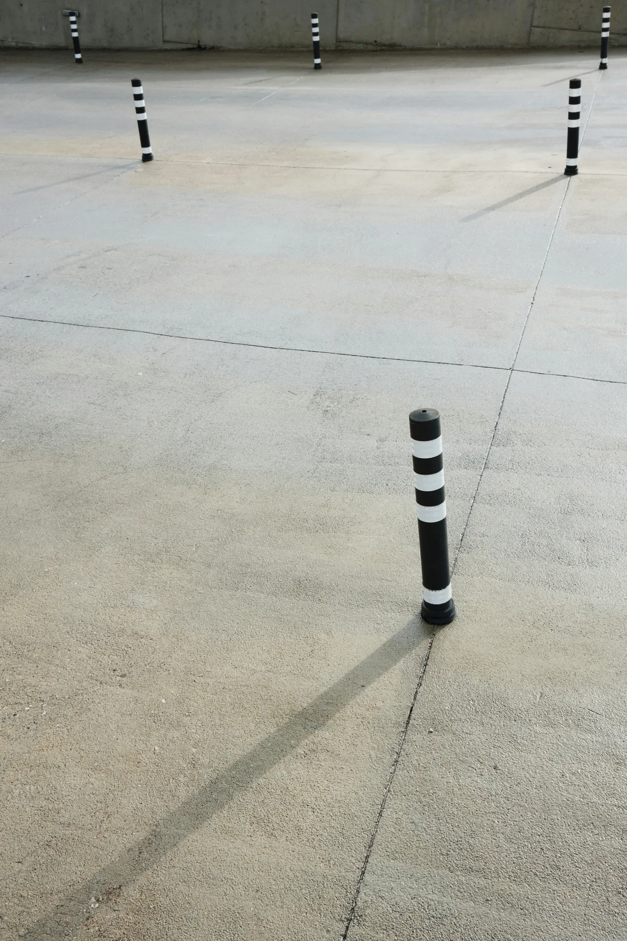 broom-finished concrete parking lot with bollards in Laval