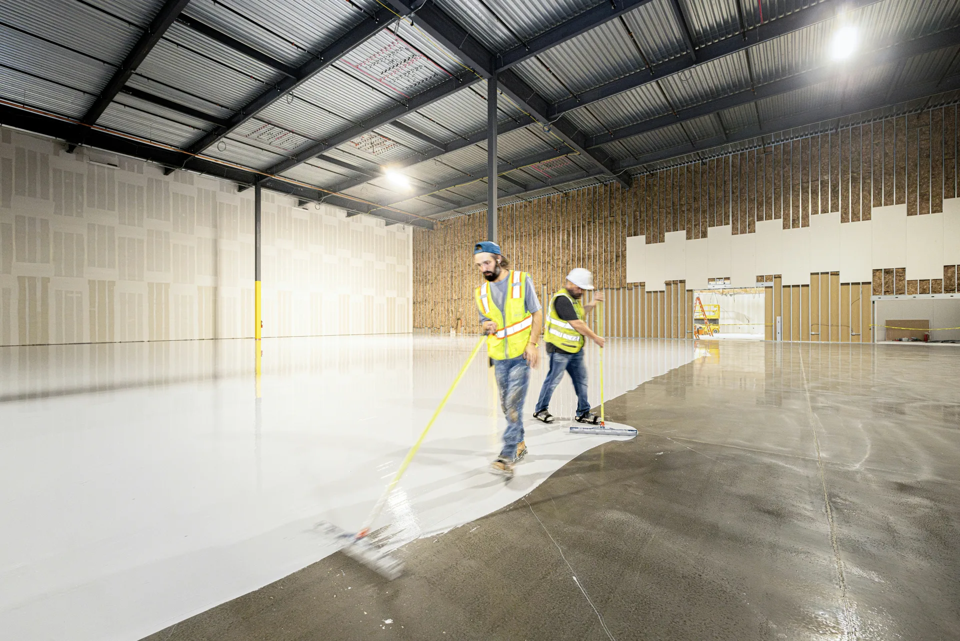 crew rolling epoxy onto a Laval garage floor