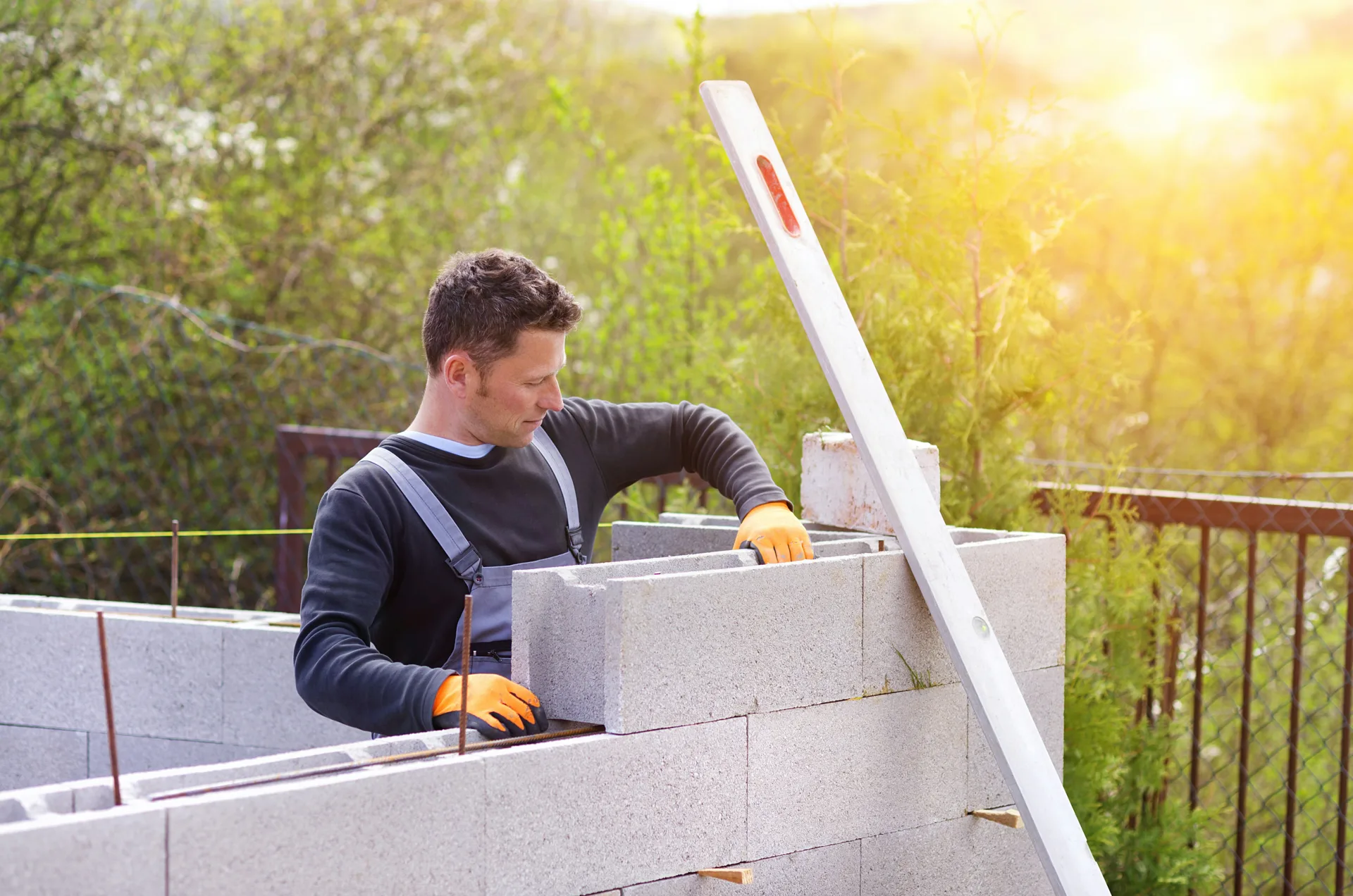 mason levelling a block retaining wall at a Laval property