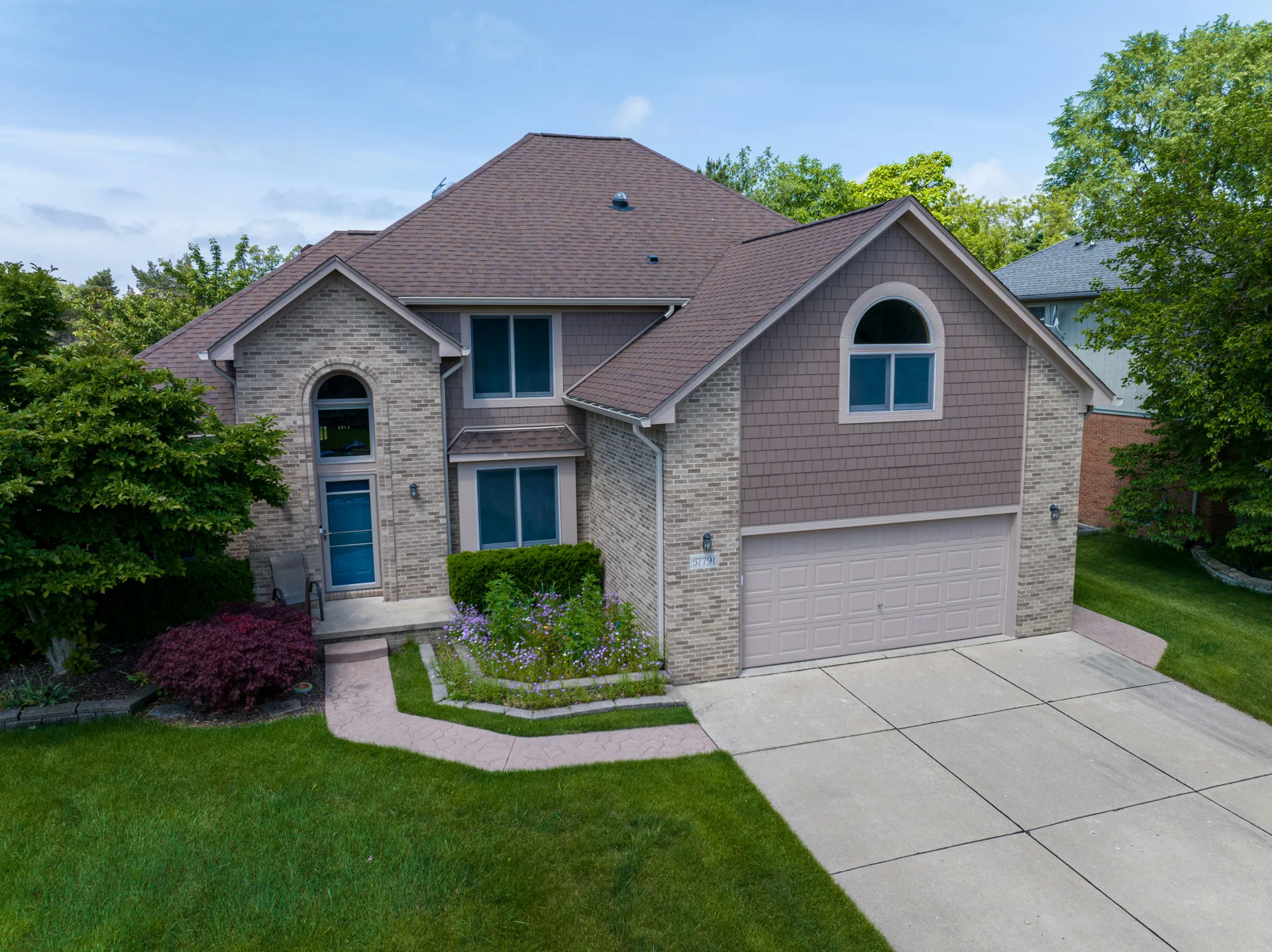 broom-finish concrete driveway at a Laval brick home
