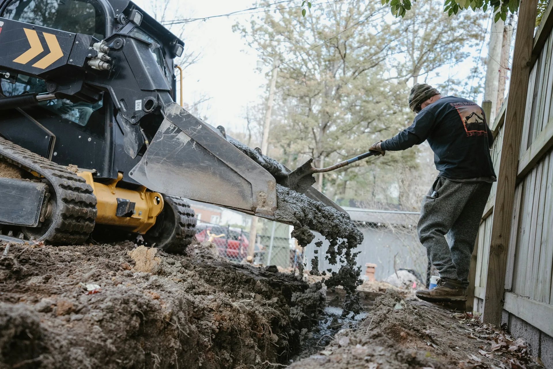 concrete foundation footing pour with a skid steer at a Laval site