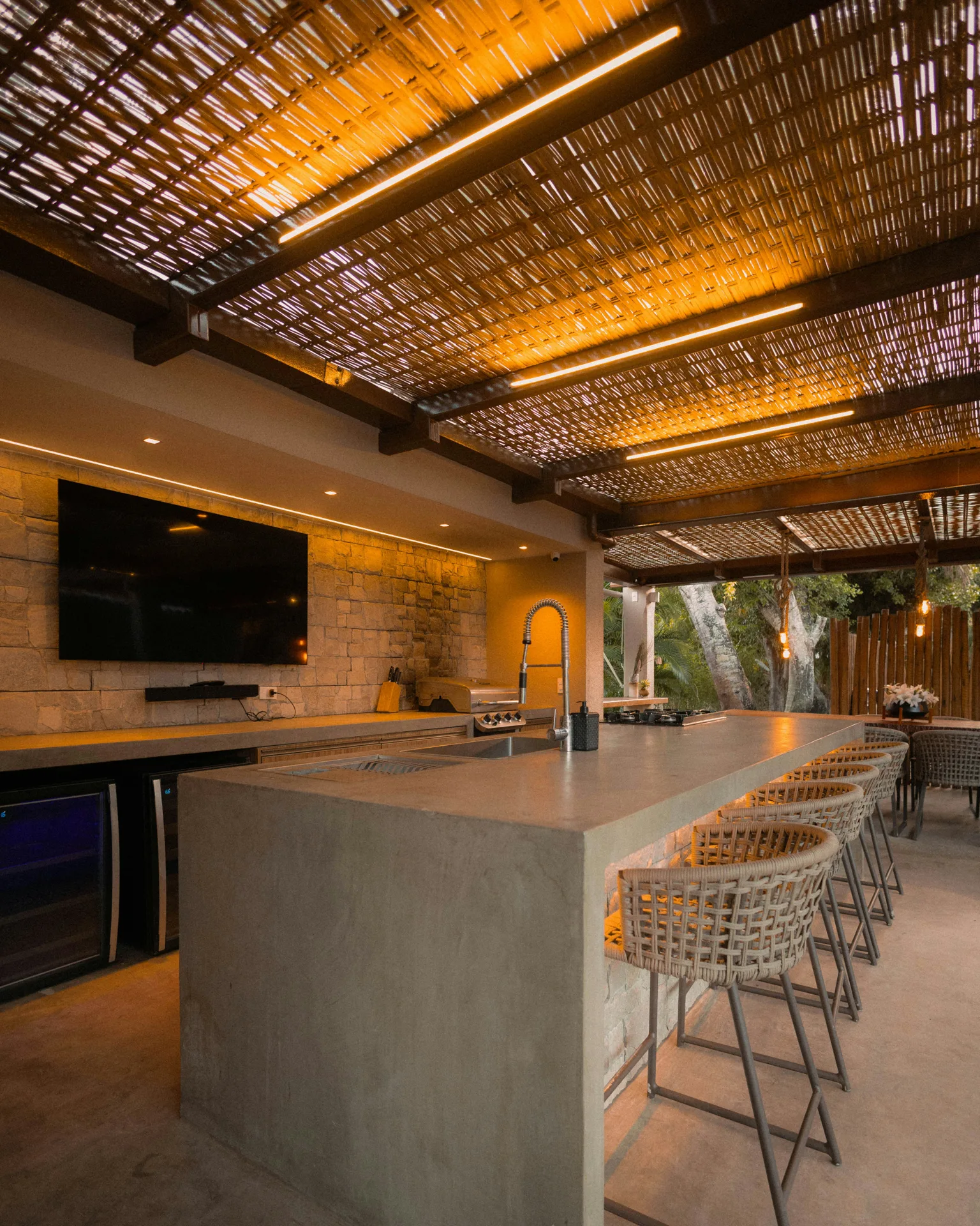 concrete outdoor kitchen bar under a pergola at a Laval home