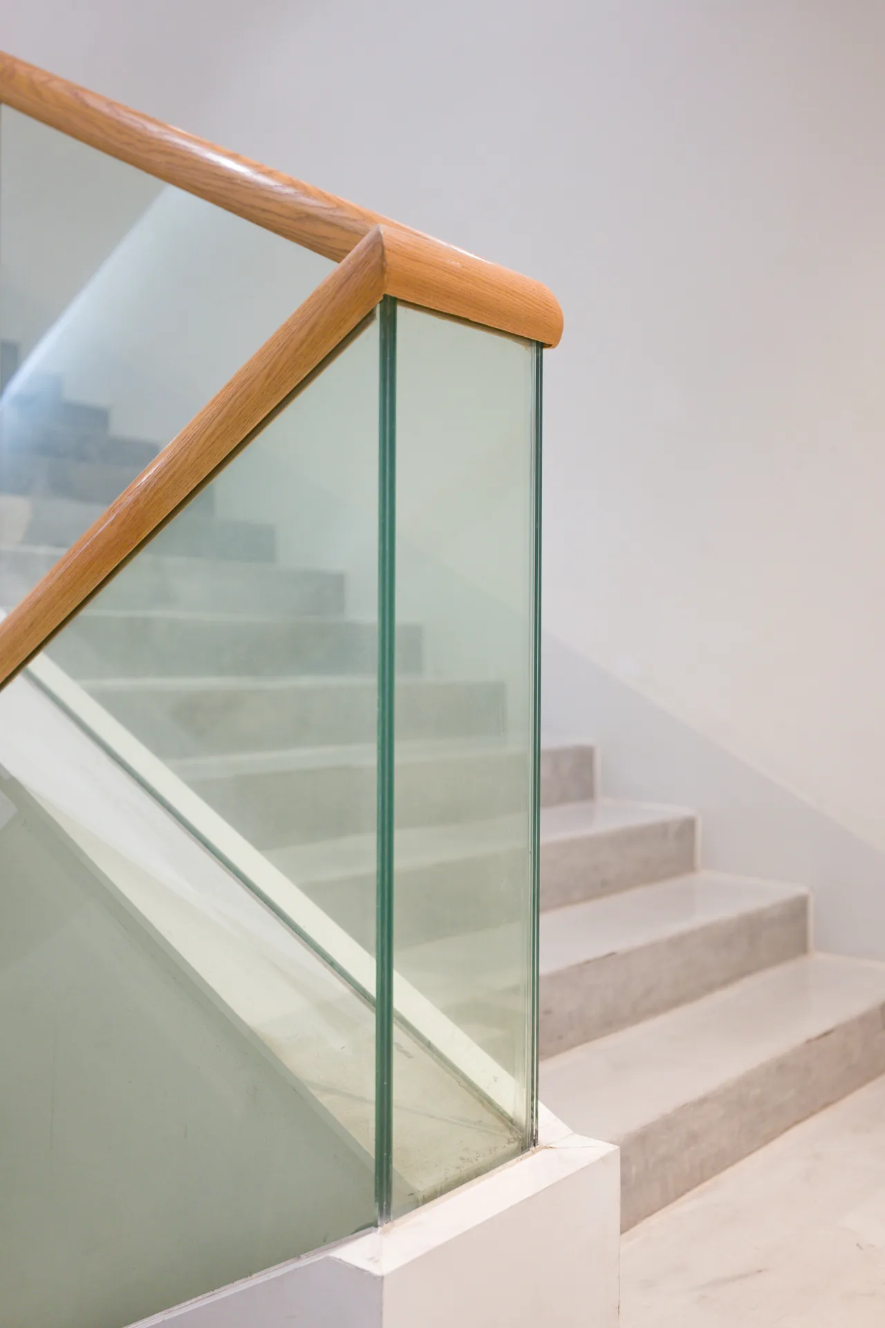 poured concrete staircase with glass railing at a Laval home